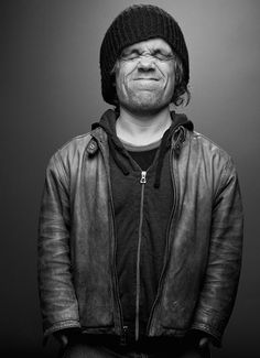 black and white photograph of a man with his eyes closed wearing a beanie hat