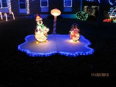 two snowmen in the yard with christmas lights