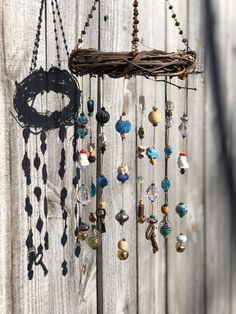 a wind chime with beads hanging from it's side on a wooden fence