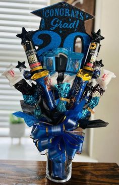 a blue graduation bouquet with chocolates and candies in it on top of a table