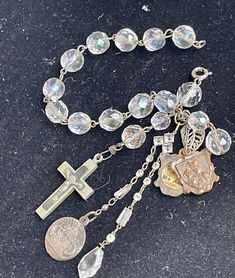 "This is a vintage crystal bead bracelet to which I have added - A vintage/antique French slide open two sided Saint Anne reliquary medal A vintage two sided Maximus medal A vintage crucifix vintage treat drop crystal 7 1/2\" (I can lengthen this bracelet if needed - at no charge. Just message me after purchase with desired length)" Vintage Silver Rosary Bracelet As Gift, Vintage Beaded Crucifix Jewelry, Vintage Adjustable Crucifix Jewelry, Vintage Faceted Beads Bracelet, Vintage Silver Rosary With Round Beads, Vintage Nickel-free Crucifix Jewelry, Vintage Jewelry With Round Bead Charms, Vintage Silver Handmade Rosary, Vintage Rosary Bracelet With Round Beads As Gift