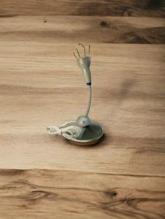 an electric toothbrush sitting on top of a wooden table next to a charger