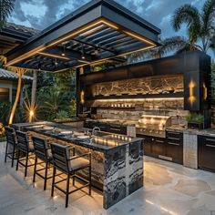 an outdoor kitchen and dining area is lit up at night with lights on the ceiling