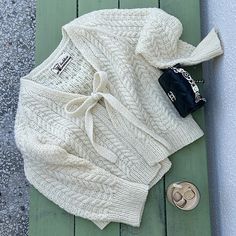 the sweater is laying next to a pair of flip flops