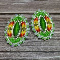 two pairs of colorful beaded earrings sitting on top of a wooden table next to each other