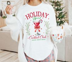 Comfort Colors® Holiday Cocktail Club Shirt, Christmas Cocktail Club shirt, Christmas Shirt, Christmas Gift, Womens Holiday Shirts, Xmas tee .: The Comfort Colors 1717 tee is made with medium fabric (6.1 oz/yd² (206.8 g/m consisting of high quality, 100% ring-spun US cotton for long-lasting comfort. .: Made using 100% US cotton that is ethically grown and harvested. Gildan is also a proud member of the US Cotton Trust Protocol ensuring ethical and sustainable means of production. SIZE ▸ Take a l Holiday Long Sleeve Shirt With Graphic Print, White Graphic Print Shirt For Holiday, Christmas Holiday Crew Neck Shirt, Festive Long Sleeve White T-shirt, White Festive Shirt For Christmas, White Festive Christmas Shirt, White Letter Print Shirt For Holiday, White Graphic Print Top For Holiday, White Long Sleeve T-shirt For Holiday