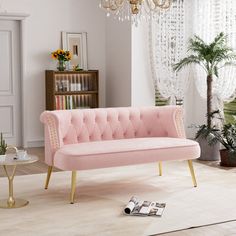 a living room with a pink couch and chandelier