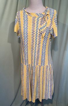 "This is a cute vintage dress from the 60s. No labels or tags, it is home sewn. No size tag. The bust measures 38\", waist 38\", see measurements below. Made of a yellow, gold, white & blue nylon in a flame style pattern. The dress is not lined. It is short sleeve with a portrait collar with small tails. The skirt has inverted pleats all around. Zips in the back with a metal zipper. The dress is in good condition, but is not perfect. There are a few pin holes, as shown in the photos. One pin Retro Blue Knee-length Vintage Dress, Vintage Blue Short Sleeve Mini Dress, Blue Vintage Short Sleeve Mini Dress, Vintage Blue Knee-length Mini Dress, Blue Retro Dress With Retro Print, Retro Knee-length Mini Dress For Daywear, Knee-length Retro Mini Dress For Daywear, Vintage Blue Mini Dress, Flame Pattern