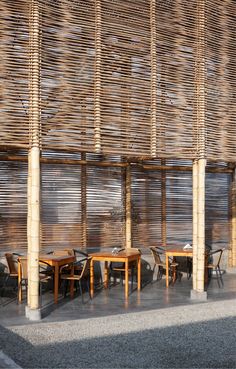 an outdoor dining area with tables and chairs made out of wooden slatted screens