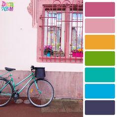 a bike parked in front of a building with pink and green paint swatches on it