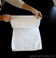 a person is holding a towel on top of a table