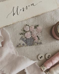 some sewing supplies are laying out on a piece of fabric with the word blossom written across it