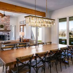 a dining room table with chairs and a chandelier hanging from it's ceiling