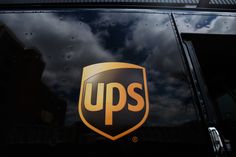 the ups logo is on the side of a truck with dark clouds in the background