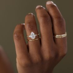 a woman's hand with two gold rings and a diamond ring on her finger