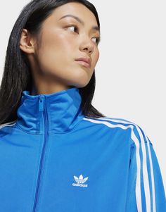 Get ready to set the streets on fire in this dynamic track top. A must-have for any adidas enthusiast, the iconic Firebird tracksuit has been making waves since the '80s with its modern-yet-authentic attitude. Crafted from a shiny recycled tricot, this jacket stays true to its sporty roots thanks to its stand-up collar and classic 3-Stripes down the sleeves. Pop it on with your favourite jeans or joggers for an effortlessly casual look that's sure to be noticed.Made with a series of recycled materials, and at least 70% recycled content, this product represents just one of adidas' solutions to help end plastic waste.• This model is 172 cm and wears a size S. Their chest measures 86 cm and the waist 61 cm.• Loose fit• Full zip with stand-up collar• 100% polyester (recycled)• Zip pockets• Rib Tracksuits For Men, Adidas Adicolor, Kids Online Shopping, Adidas Classic, Adidas Tracksuit, Adidas Girl, Adidas Blue, Vest Outfits, Firebird