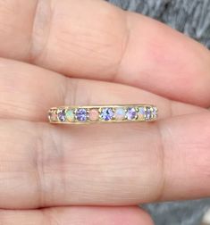 Natural Tanzanite Opal Alternating 3mm Half Eternity Band MaterialSolid Gold (14K/ 18K) or Platinum 950 FinishingHigh Polished/Shiny PlatingRhodium/Platinum Family (Only if white gold selected) FitStandard Fit Width3 mm Height1.8 mm SettingPave Prong Stone #1Natural Opal ShapeRound Cabochon ColorWhite with Fire-like hues of Orange, Yellow and Red Stone #2Natural Tanzanite ColorLavender with Purple and Blue Hues Cut & ShapeRound, Diamond Cut QualityAAA Click below to add laser engraving. http Lavender Opal, Wedding Anniversary Ring, Opal Band, Custom Wedding Band, Sapphire Band, Sparkly Things, Wedding Anniversary Rings, Sapphire Wedding, Matching Wedding Bands