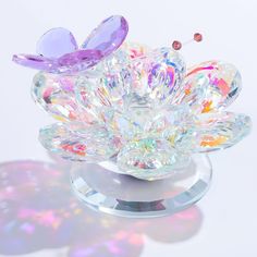 a crystal flower with two butterflies on it's top and some other things in the background