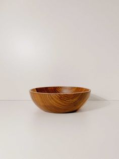 a wooden bowl sitting on top of a white table