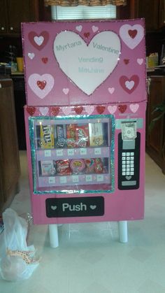 a pink vending machine with hearts on it