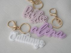 three different key chains with the words bride and alpena on them, sitting next to each other