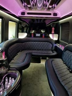 the inside of a limo with black leather seats and purple lighting on it's ceiling