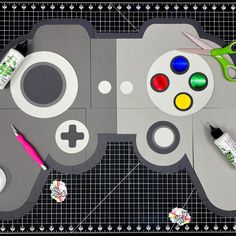 a video game controller cut out with scissors and markers