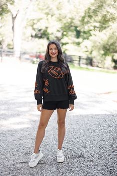 Black terry knit pullover accented with embroidered footballs and 'touchdown' In the Fall we are all Touchdown Obsessed!! Show your gameday spirit in this fabulous black sweatshirt, featuring brown embroidery braided footballs and the word 'touchdown' on the front and down the sleeves. With a crew neckline and long balloon sleeves, she's as comfy as she is festive. Tailgating never looked so stylish! True to size fit; relaxed silhouette Model is 5'5" wearing a small Fabric contains stretch Ribbe Football Party Outfit, Tailgating Outfits, Brown Embroidery, Tailgate Outfit, Football Sweatshirt, Graphic Tee Dress, Football Party, Vintage Couture, Black Sweatshirt