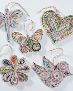 four pieces of paper are arranged in the shape of heart and butterfly shapes, with string attached to them