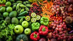 many different types of fruits and vegetables are arranged in the shape of a rainbow color scheme