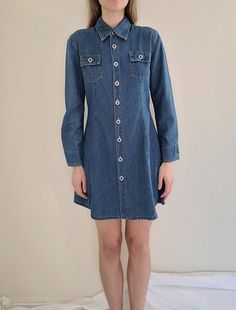 "1990s long sleeve, two front chest pockets, two pockets on back, hits just above the knee tagged size large, I think it fits a bit more like a medium, see measurements for fit measurements: length 33\", waist 32\", pit-to-pit 19\"  100% cotton, machine wash, made in USA excellent pre-owned condition, no flaws or damage Feel free to bundle with other items Items are pre-owned with possible flaws as expected with vintage. Major flaws will be noted in description." Blue Long Sleeve Denim Dress With Buttoned Pockets, Fitted Long Sleeve Denim Dress With Pockets, Relaxed Fit Long Sleeve Denim Dress, Long Sleeve Denim Dress With Buttons, Long Sleeve Denim Dress With Button Closure, Long Sleeve Denim Dress With Pockets For Work, Vintage Long-sleeve Denim Dress For Spring, Vintage Long Sleeve Denim Dress With Pockets, Vintage Denim Blue Denim Dress With Pockets