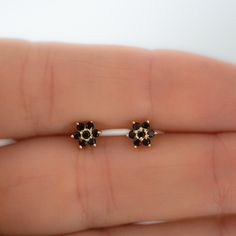 Dainty flower shaped stud earrings. Perfect for pairing with multiple piercings. Available in Black or Black with White CZ Stone DETAILS * Thick plating of 14k Gold or Rhodium over 925 Sterling Silver * Sold as a Pair * Hypoallergenic and nickel-free * 5 mm x 5 mm * Also available in white cz, ruby, sapphire or emerald Huggies on Model: https://www.etsy.com/listing/708078947/sapphire-huggie-earrings-gold-cz-huggies?ga_search_query=black%2Bhuggies&ref=shop_items_search_1&pro=1 Made with 1 Black Stone Studs In Gold, Black Stone Earrings Gold, Stone Earrings Studs, Bali Design, Black Stone Earrings, Black Diamond Earrings Studs, Nose Pins, Black Diamond Studs, Huggie Earrings Gold