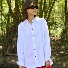 The "Idalia-Meryl" linen shirt combines elegance with comfort. Made from high-quality 100% Polish linen, it is durable and pleasant to the touch. The densely woven fabric ensures discretion, allowing the shirt to be worn without underwear. Its oversized cut with a longer back and rounded side slits adds lightness and a feminine touch. The multicolored buttons highlight its originality, while the natural colors inspired by Africa give the shirt a unique look. It can be worn in various ways, such White Linen Blouse With Spread Collar, White Linen Blouse With Button Cuffs, Shirt Blouses Women's, June Birthstone Jewelry, Gifts For New Mums, Jewelry Ring Box, Pearl Jewellery Earrings, Roll Up Sleeves, Evil Eye Jewelry