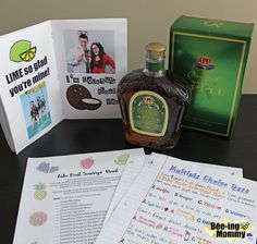 a bottle of liquor sitting on top of a table next to papers and an open book