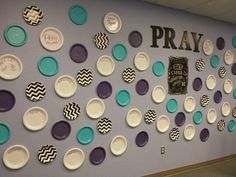 the wall is decorated with plates and saying pray