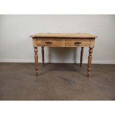 an old wooden table with two drawers on one side and a drawer on the other