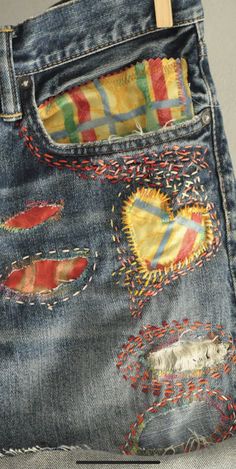 an old pair of jeans with patches and hearts on them