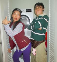 two people standing next to each other in front of a dryer door with their hands up