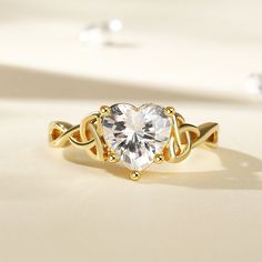 a gold ring with a heart shaped diamond