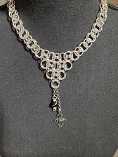 a silver necklace is on display on a mannequin