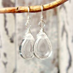 "These remind me of crystal raindrops. A best seller in my shop. Crystal Clear Czech glass briolettes are wire wrapped with sterling silver wire and dangled from sterling ear wires. The briolette size is 10x14mm. The earrings measure 1 1/2\" from the top of the sterling ear wire. Lightweight and comfortable for all day wear. See the larger version here: https://www.etsy.com/listing/1174059675/clear-glass-earrings-large-sterling?click_key=01f2e3f6618863e2a620f381edd1861dae4f1d71%3A1174059675& Clear Crystal Bracelet, Clear Bracelet, Clear Crystal Earrings, Heart Accessories, Semiprecious Stone Jewelry, Clear Earrings, Glass Drop Earrings, Buy Earrings, Teardrop Dangle Earrings