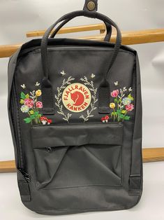 Welcome to our charming collection of hand-embroidered Fjallraven Kanken backpacks, meticulously crafted with love and precision. Elevate your style and stay organized on-the-go with these premium quality backpacks available in two convenient sizes:  - Medium (27x38x13cm)  - Large (32x42x13cm) + Key Features: - Hand-Embroidered Excellence: Each Fjallraven Kanken backpack is adorned with exquisite hand-embroidery, creating a unique and exclusive piece that sets you apart from the crowd. - Premium Fjallraven Kanken Embroidered, Kanken Classic, Embroidered Backpack, Wallpaper Iphone Love, Embroidered Name, Cute Embroidery, Flower Embroidery Designs, Embroidered Bag, Classic Backpack