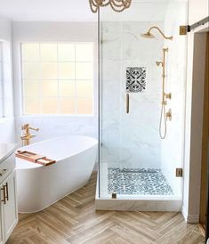 a bathroom with a white tub and wooden floors