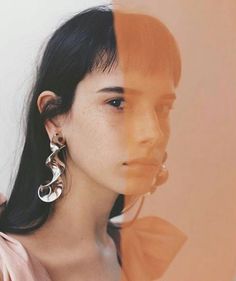 a woman with long black hair wearing large silver hoop earrings on her ear and looking off to the side