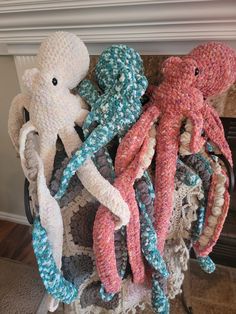 crocheted octopus stuffed animal sitting on top of a pile of knitted items