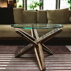 a glass table sitting on top of a rug next to a couch