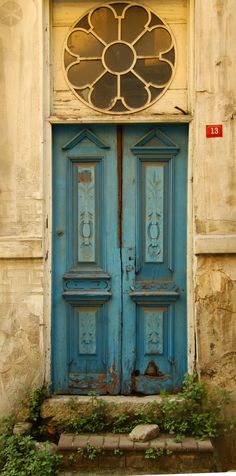 an old blue door with a round window