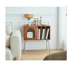 a living room with a couch, table and bookshelf on the floor in front of a white wall