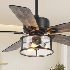 a ceiling fan with two wooden blades and glass shades on the light fixture in a living room