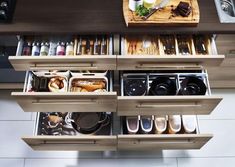 an organized kitchen drawer with utensils and other items on the shelves in it